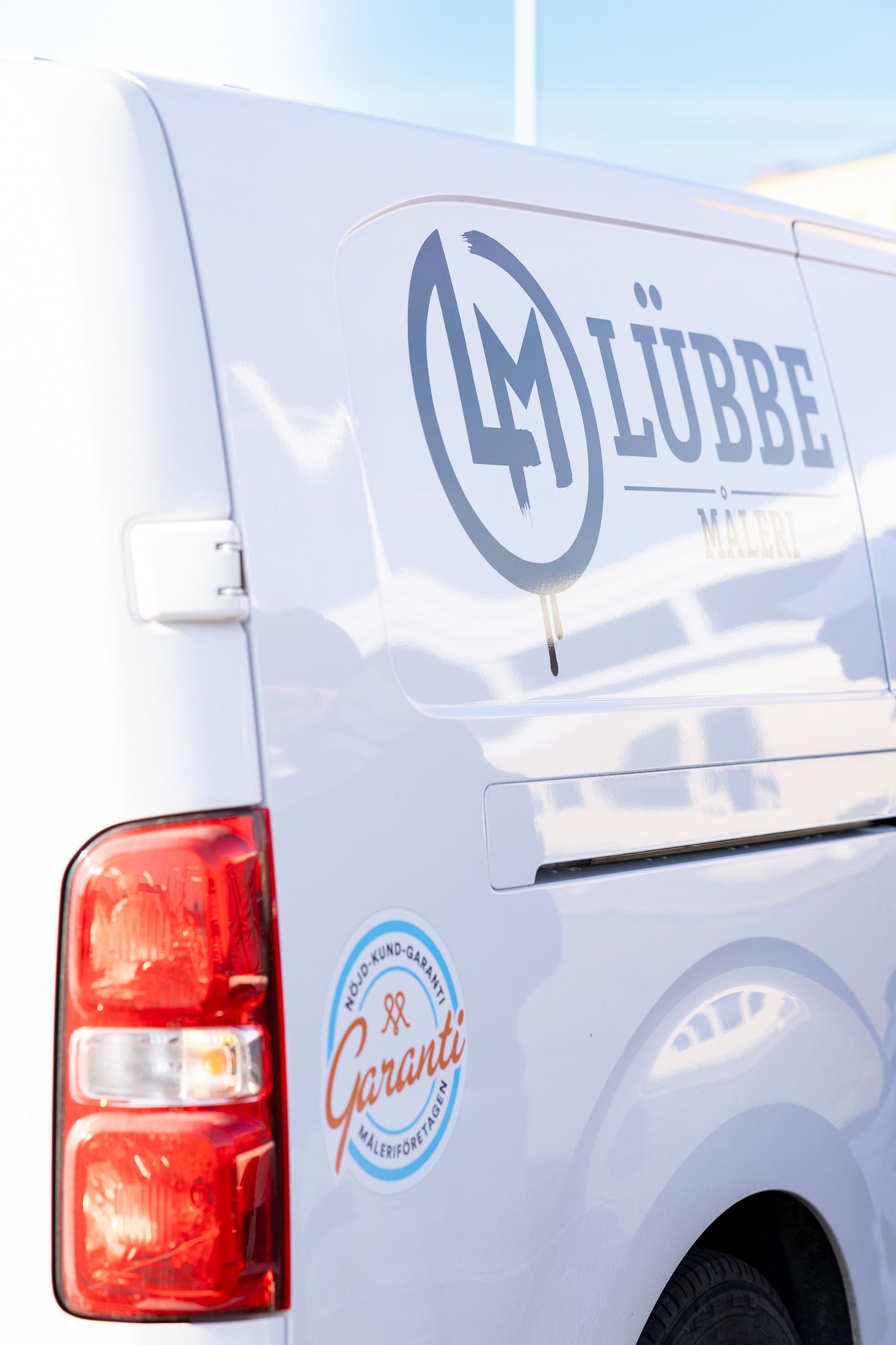 Lübbe Måleris logga och Nöjd-kund-garanti-dekal på servicebilen
