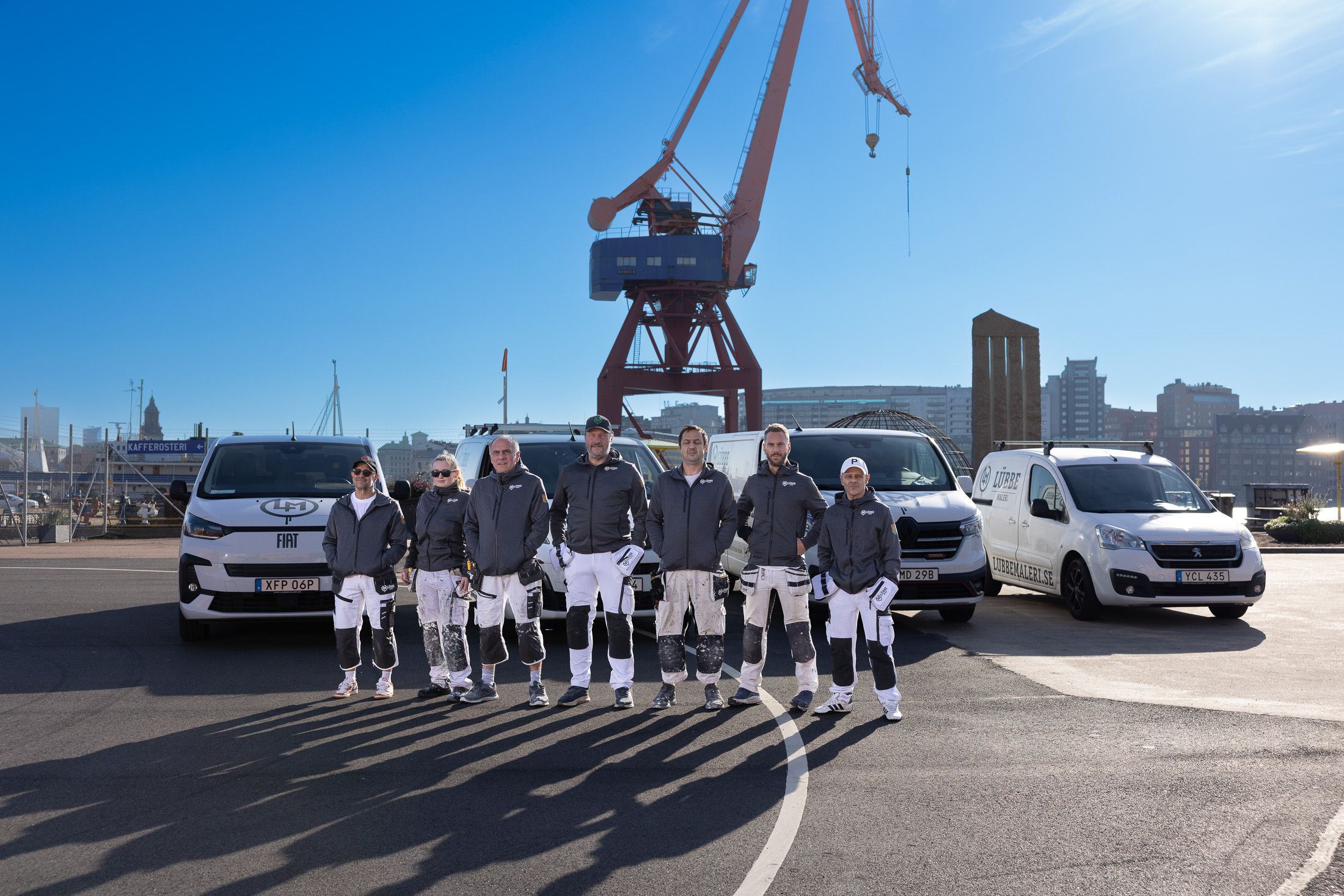 Hela teamet på Lübbe Måleri framför servicebilarna och kranen i Göteborgs hamn
